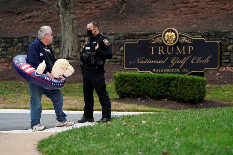 A supporter of President Donald Trump speaks to a police officer as he waits for Trump to depart the Trump National Golf Club in Sterling, Virginia, November 21. REUTERS/Joshua Roberts